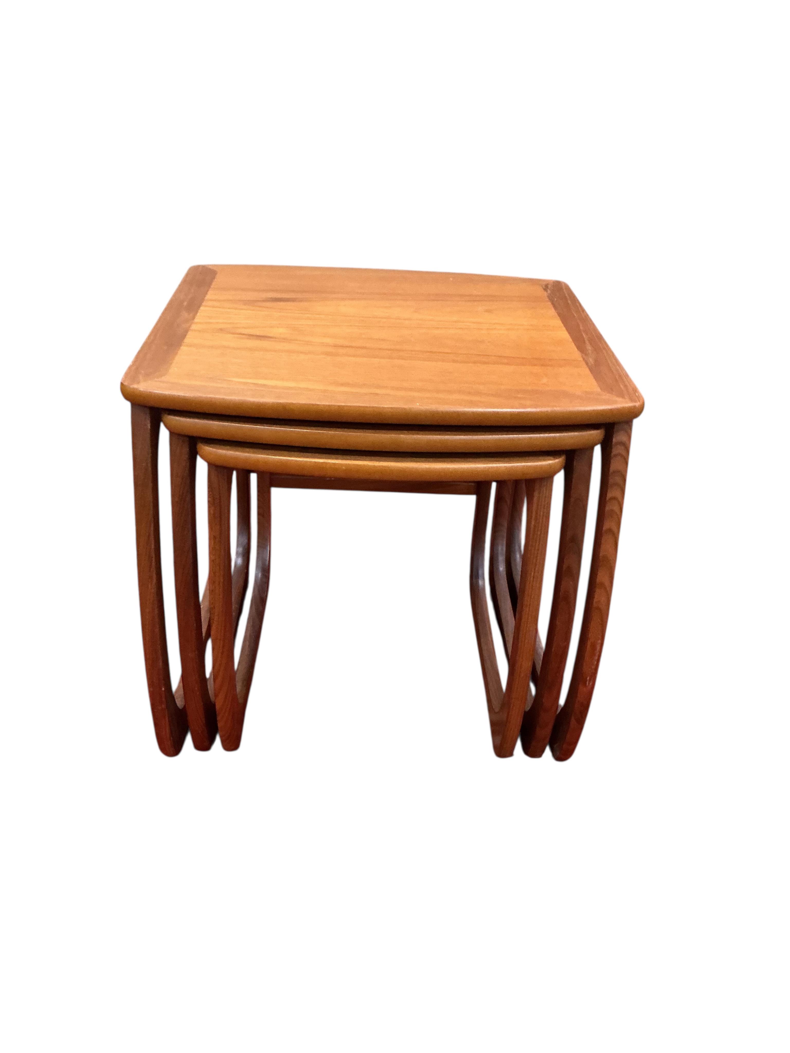 A nest of three mid century Nathan teak tea tables, width 52cm, depth 48cm, height 50cm together with a mid century teak coffee table